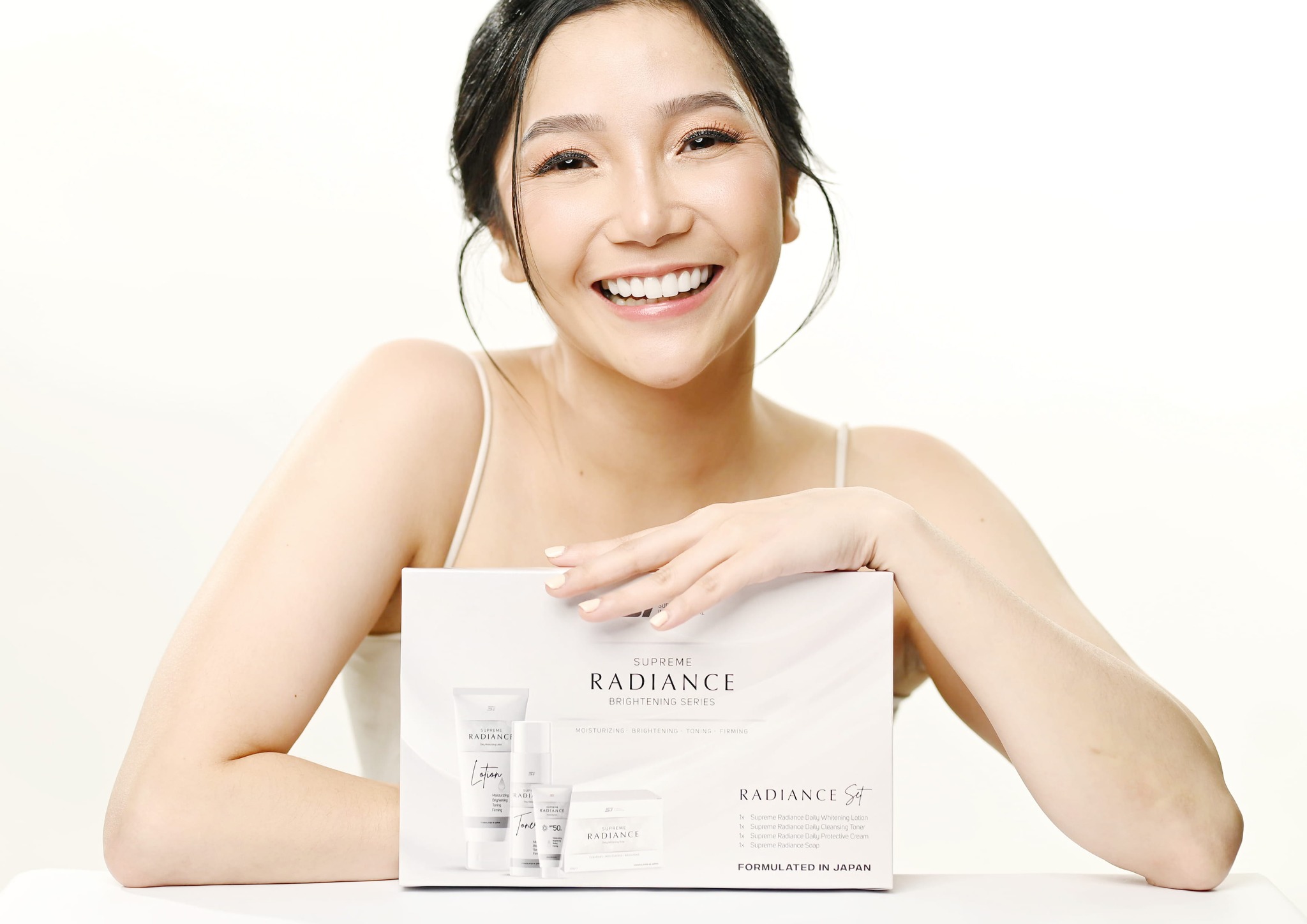 Supreme Radiance beauty campaign featuring a smiling woman presenting the brightening skincare collection